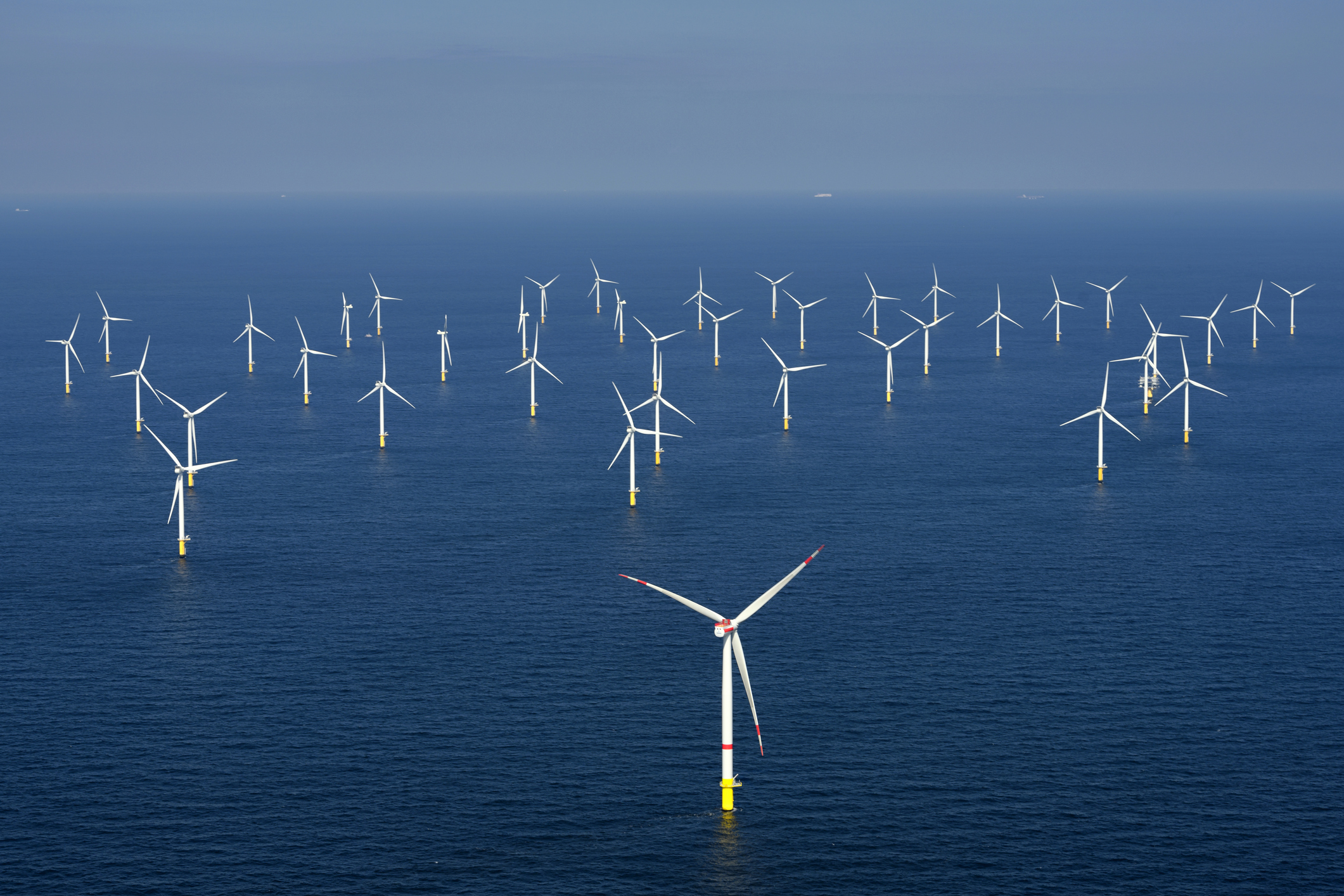 Offshore wind farm with ships barely visible in horizon